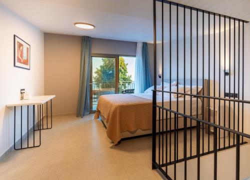 a hotel room with a bed and a balcony at Eucalyptus Sea Houses in Preveza