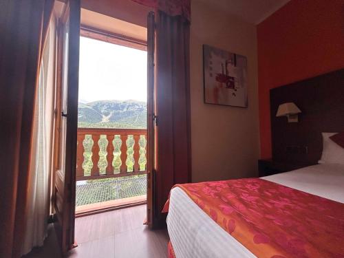 a bedroom with a bed and a large window at Hotel Solineu in La Molina