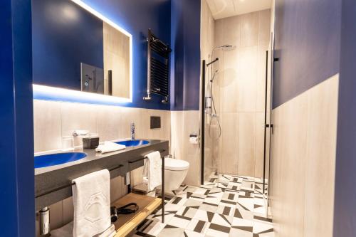 a bathroom with two sinks and a shower at Hotel Oktogon Haggenmacher by Continental Group in Budapest