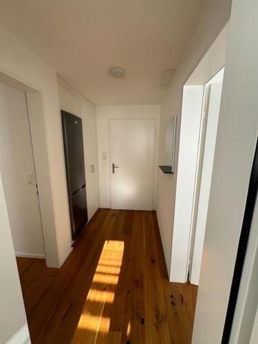an empty room with a wooden floor and white walls at Apartment Oberrüti in Oberrüti