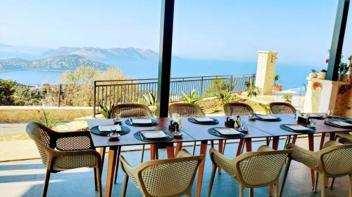 een tafel en stoelen met uitzicht op de oceaan bij Kaleli Deluxe Homes in Kas