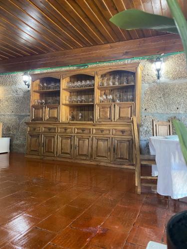 a wooden cabinet in a room with a table at Casa Augusta - QUINTA in Penafiel