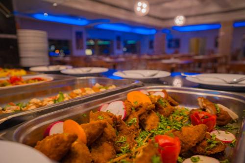 a buffet with many trays of food in a restaurant at Marina Sharm Hotel in Sharm El Sheikh