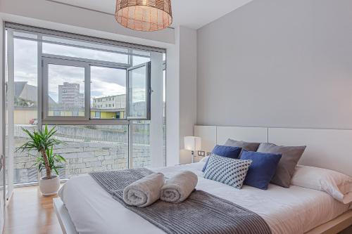 ein Schlafzimmer mit einem großen Bett mit einem großen Fenster in der Unterkunft Blue Ocean Apartment in A Coruña