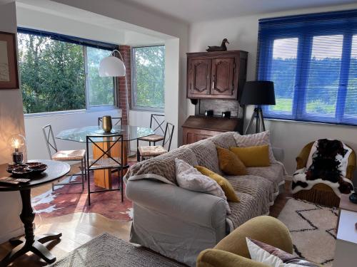 un salon avec un canapé et une table dans l'établissement LES FERMES DE PINPIN - LE PAVILLON, à Labaroche