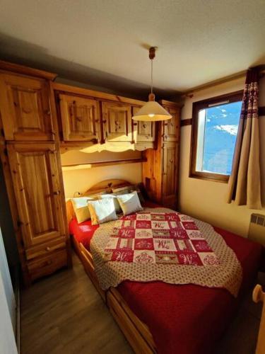 Schlafzimmer mit einem Bett mit einer roten und weißen Decke in der Unterkunft Condo in val thorens by AlpStays in Val Thorens