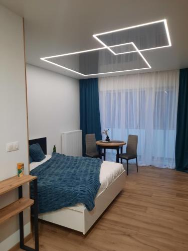 a bedroom with a bed and a table at LOCUS SKY TOWER Katowice in Katowice