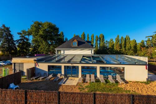 a house with a lot of windows and chairs at Garrigae Manoir de Beauvoir Poitiers Sud - Hotel & Spa in Mignaloux-Beauvoir