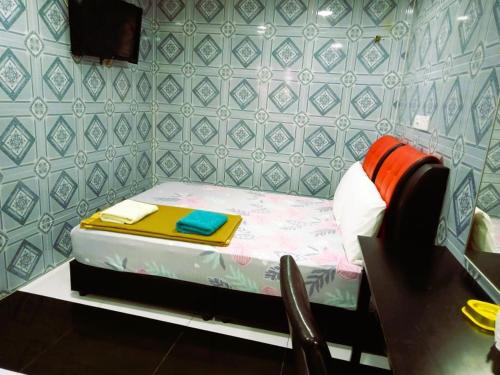a small bedroom with a small bed with a table at Kuala Selangor Hotel in Kuala Selangor