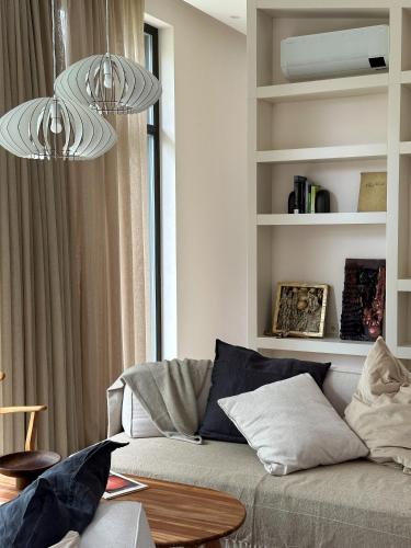 a living room with a couch and two chandeliers at IVIS House Lakeside Retreat in Vilnius in Vilnius