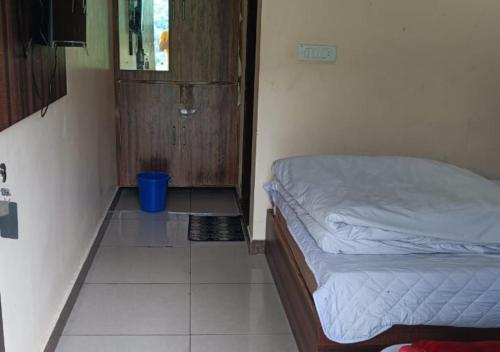a small bedroom with a bed and a door at RK Residency Ukhimath in Ukhimath
