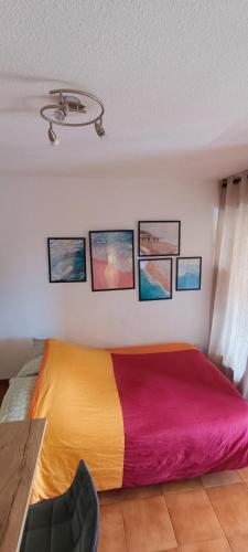 une chambre avec un lit coloré avec des images sur le mur dans l'établissement Studio 4 pers coeur du Lavandou 5mn à pied des plages, au Lavandou
