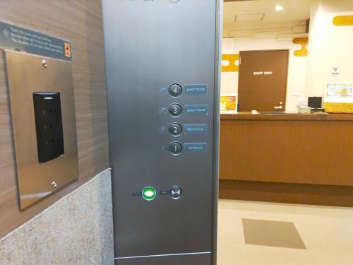 a elevator with a green button in an airport at PREMIUM TOJI in Kyoto