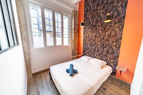 Cette chambre comprend un lit avec une croix bleue. dans l'établissement 