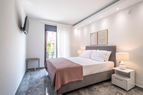 a bedroom with a large bed and a window at Orion Luxury Apartments in Nafplio