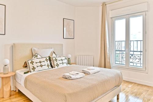 une chambre avec un lit avec deux serviettes dessus dans l'établissement Séjour dans un 2 pièces confortable - Proche Paris - II, à Montreuil