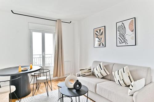 un salon blanc avec un canapé et une table dans l'établissement Séjour dans un 2 pièces confortable - Proche Paris - II, à Montreuil