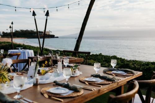 a table set up for a wedding with the ocean in the background at Royal Lahaina Resort & Bungalows in Lahaina