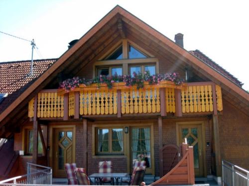a house with a balcony with flowers on it at Fewo mit Balkon und herrlicher Fernsicht in Wittenschwand
