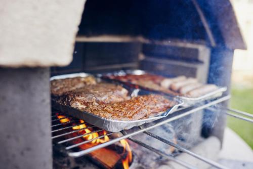 a grill with a bunch of food cooking on it at Mein rotes Haus in Wandlitz