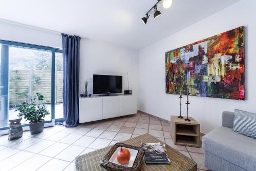 a living room with a couch and a tv at Einfach nur schön in Oberhausen