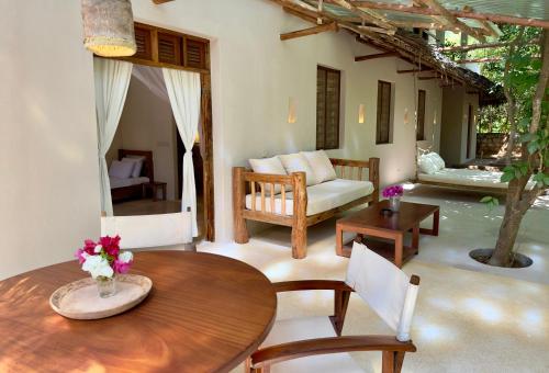 a living room with a wooden table and chairs at Palm Garden ECO Boutique Hotel No Kids under 12 in Watamu