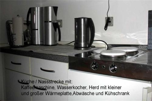 a kitchen counter with two coffee makers on a stove at Ferienwohnung am Rentierweg in Rathenow