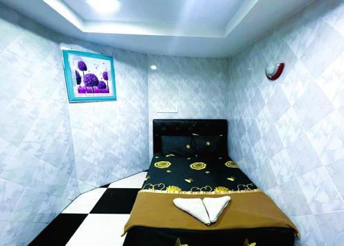 a small bedroom with a bed in the corner at Bukit Beruntung Hotel in Rawang