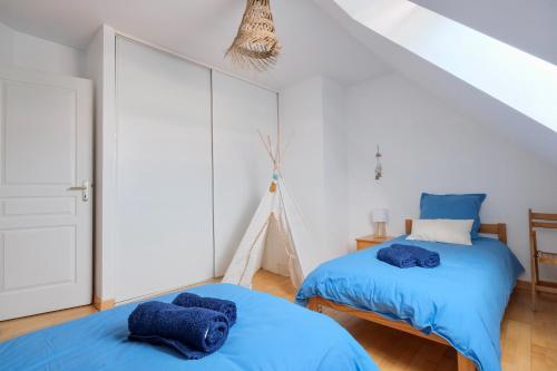 - 2 lits dans une chambre avec des draps bleus dans l'établissement L'Oyat, à Barneville-Carteret