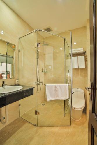 a bathroom with a shower and a toilet and a sink at Dalat Paradise Hotel in Da Lat