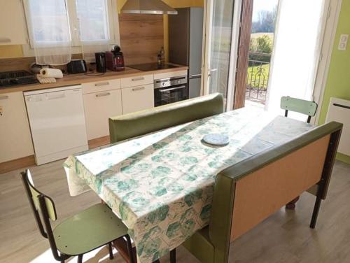 une cuisine avec une table recouverte d'une nappe dans l'établissement Appartement Saint-Laurent-du-Cros, à Saint-Laurent-du-Cros