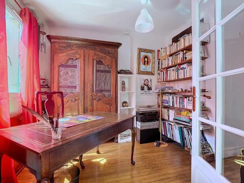Cette chambre comprend un bureau en bois et une étagère à livres. dans l'établissement Duplex Évasion Shanti - à 3 min du Métro, à Charenton-le-Pont