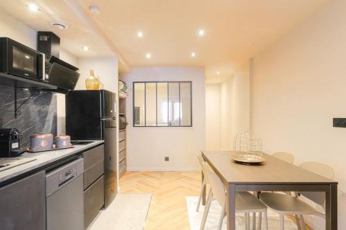 une cuisine avec une table et une salle à manger dans l'établissement Appartement lumineux pour 4, Villeurbanne Cusset, à Villeurbanne