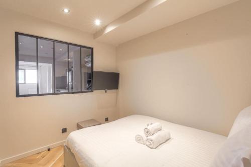 une chambre avec un lit avec des serviettes dessus dans l'établissement Appartement lumineux pour 4, Villeurbanne Cusset, à Villeurbanne