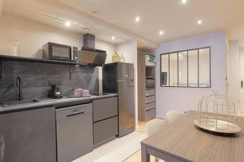 Il comprend une cuisine et une salle à manger avec une table. dans l'établissement Appartement lumineux pour 4, Villeurbanne Cusset, à Villeurbanne