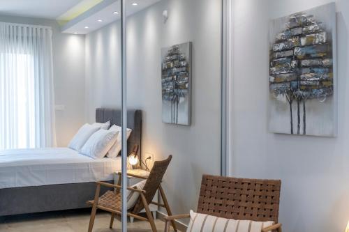 a bedroom with a bed and two chairs at Orion Luxury Apartments in Asini