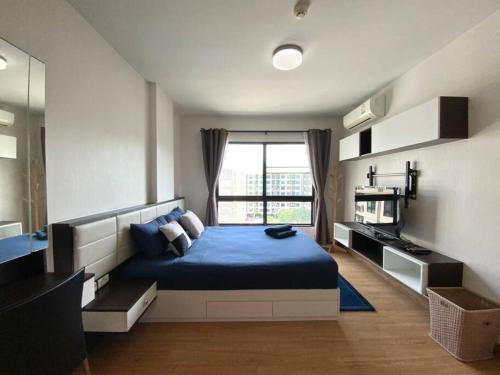 a bedroom with a blue bed and a window at Home at Sena in Bangkok