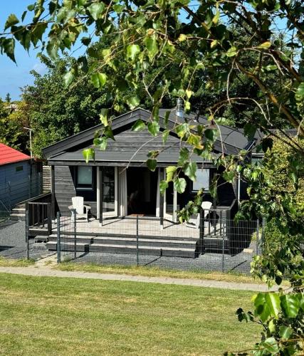 a house with a fence in front of it at Huisje Aangenaam in Dirkshorn