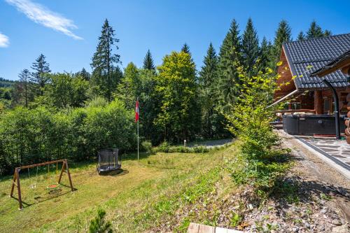 a yard with a swing set in the grass at Chalet Piros Tale - Sauna - Jacuzzi - Beautiful scenery - Kids playground - In the forest in Tale