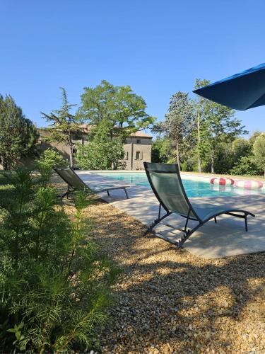 deux chaises assises à côté d'une piscine dans l'établissement Maison vigneronne de Bonne Maman - climatisée, à Cesseras
