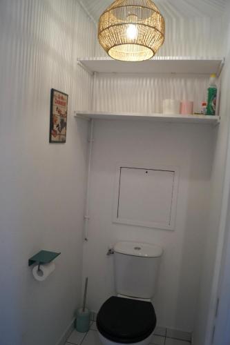 La salle de bains est pourvue de toilettes avec un siège noir et une lampe. dans l'établissement Appartement calme et lumineux à 5 mn de Paris, à Saint-Denis