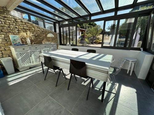 Cette chambre dispose de fenêtres et d'une terrasse avec une table et des chaises. dans l'établissement DUNe, aux Portes