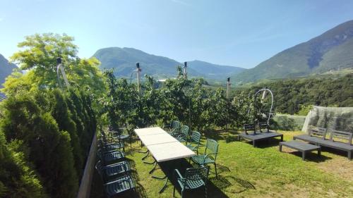 a group of chairs and a table and benches at Dolomiti Brenta apartment da Gloria in Dercolo 