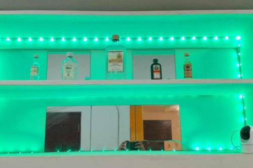 a green shelf with bottles on it with a mirror at JC's Apartment in Bacolod