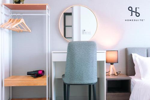 a bedroom with a desk and a chair in front of a mirror at Homesuite' Home at Jesselton Quay in Kota Kinabalu
