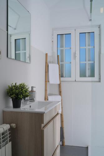 a bathroom with a sink and two windows at Casa do Limoeiro 1 in Valezim