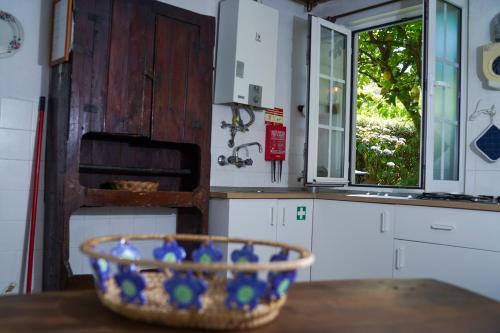 a bowl on a table in a kitchen with a window at Casa do Limoeiro 1 in Valezim