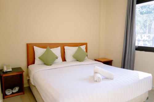 Postel nebo postele na pokoji v ubytování Kartika Sriwijaya Hotel