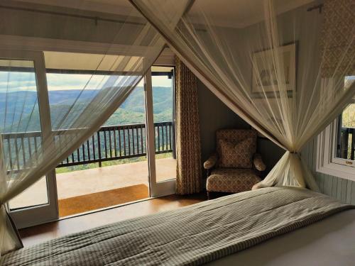 a bedroom with a bed and a chair and a large window at Camp Figtree by The Oyster Collection in Addo