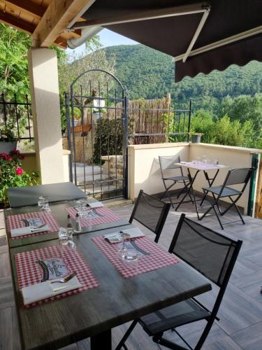 une table et des chaises sur une terrasse avec vue dans l'établissement Gîte de la tourterelle, à Saint-Florent-sur-Auzonnet